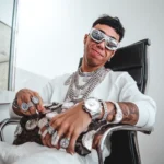 A man displaying multiple luxury watches and diamond rings, representing the need for brand protection and authenticity verification in the high-end jewelry market.